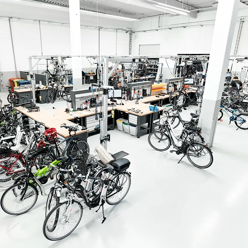 Blick in die Prophete Werkstatt – professioneller Service an mehreren Arbeitsstationen Vogelperspektive auf Prophete Fahrrad- und E-Bike-Werkstatt mit mehreren Arbeitsplätzen und diversen Rädern
