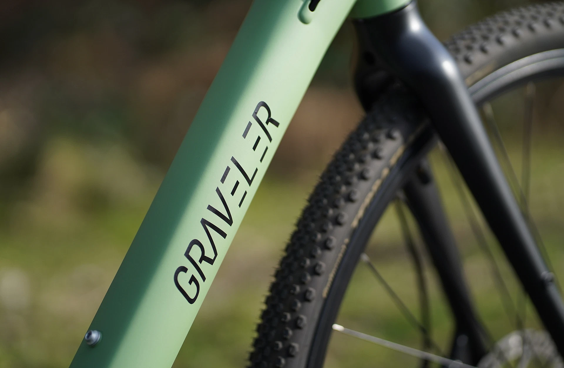 Bildausschnitt Detailansicht Unterrohr am Gravelrahmen mit Graveler Logo vor unscharfem Hintergrund