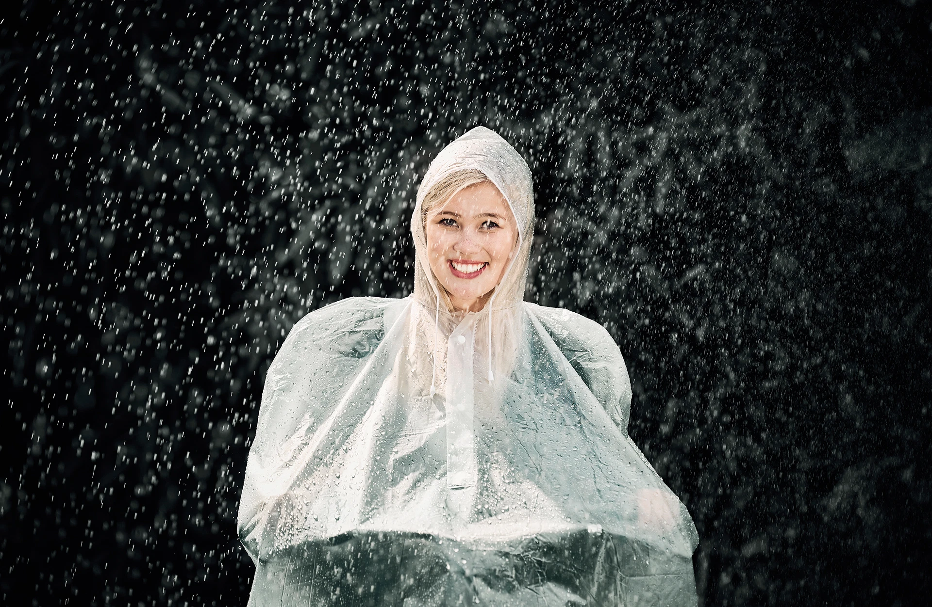 Regenumhang weiß von Frau im Regen getragen auf schwarzem Grund