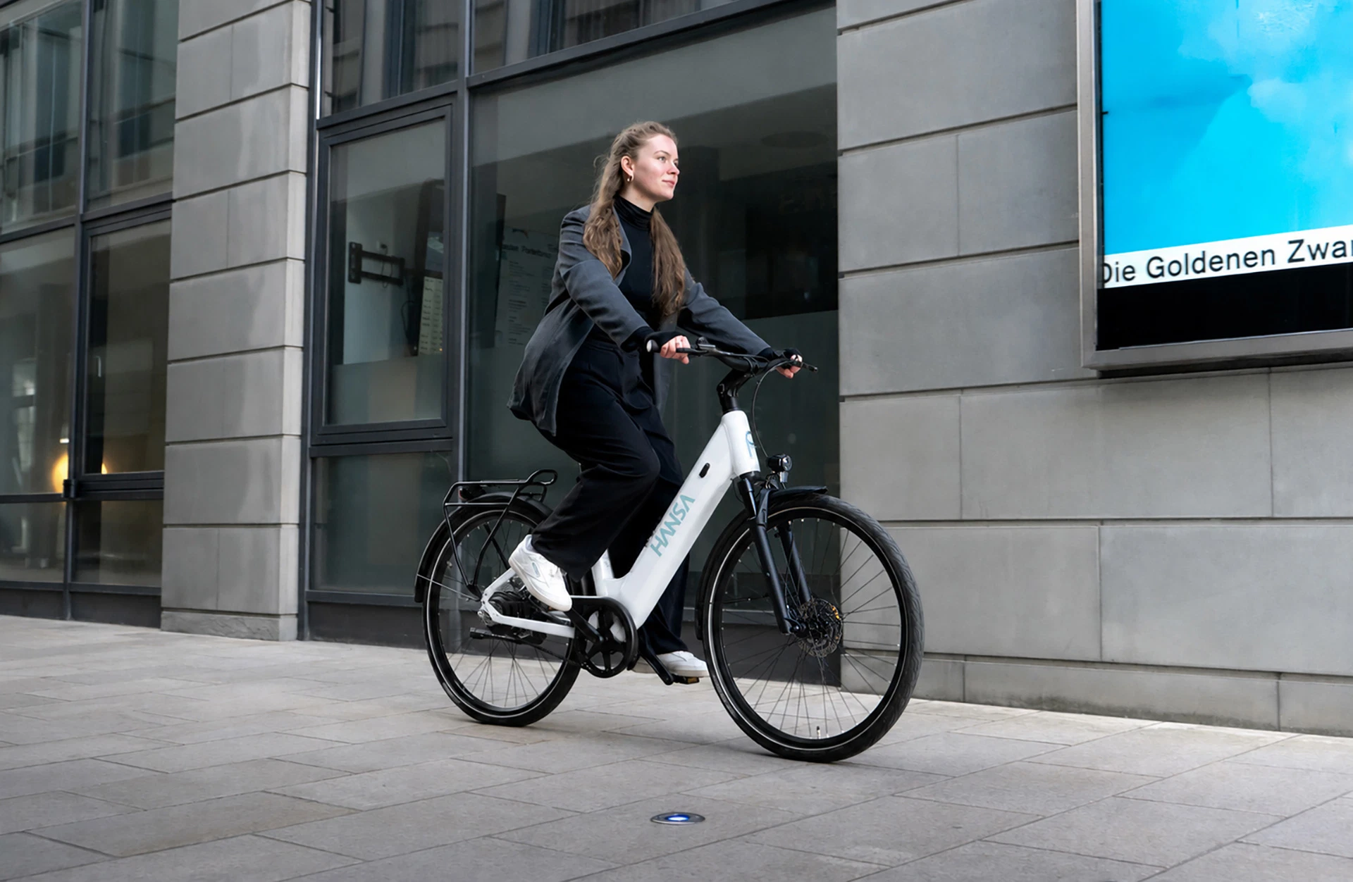 E-Bike Hansa wolkenweiß - Person fährt durch Innenstadt