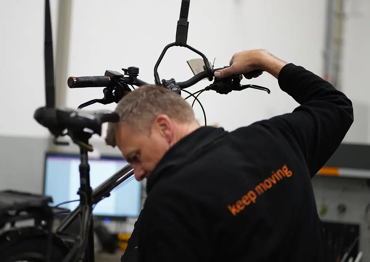 E-Bike am Kran mit Monteur im Vordergrund