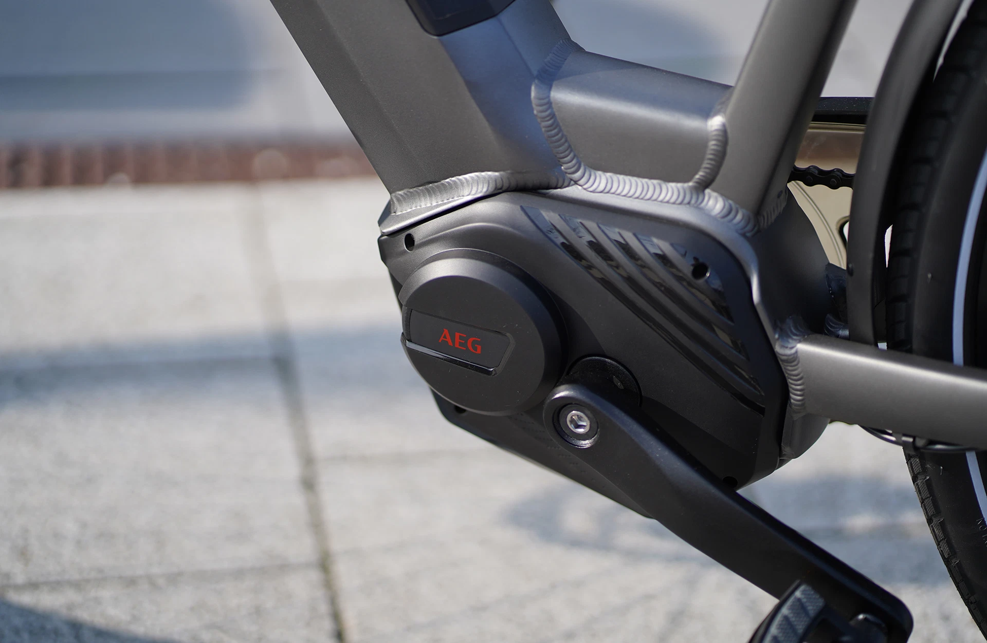 Bildausschnitt Detailansicht AEG Mittelmotor mit Kurbelgarnitur vor grauem Hintergrund (unscharf)