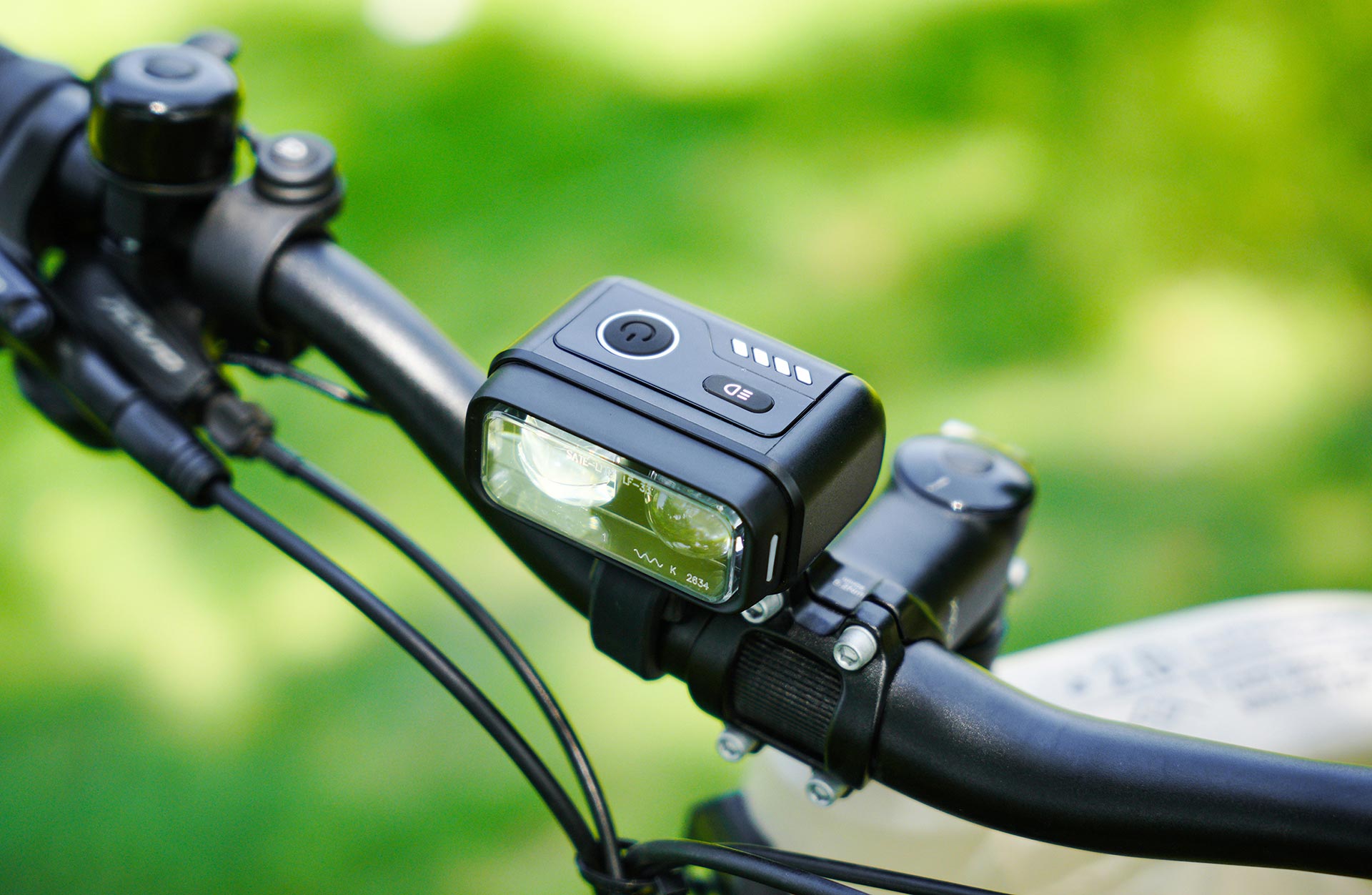 Vollansicht von vorne Scheinwerfer mit Fernlicht Bedieneinheit am E-Bike Lenker vor natürlichem Hintergrund