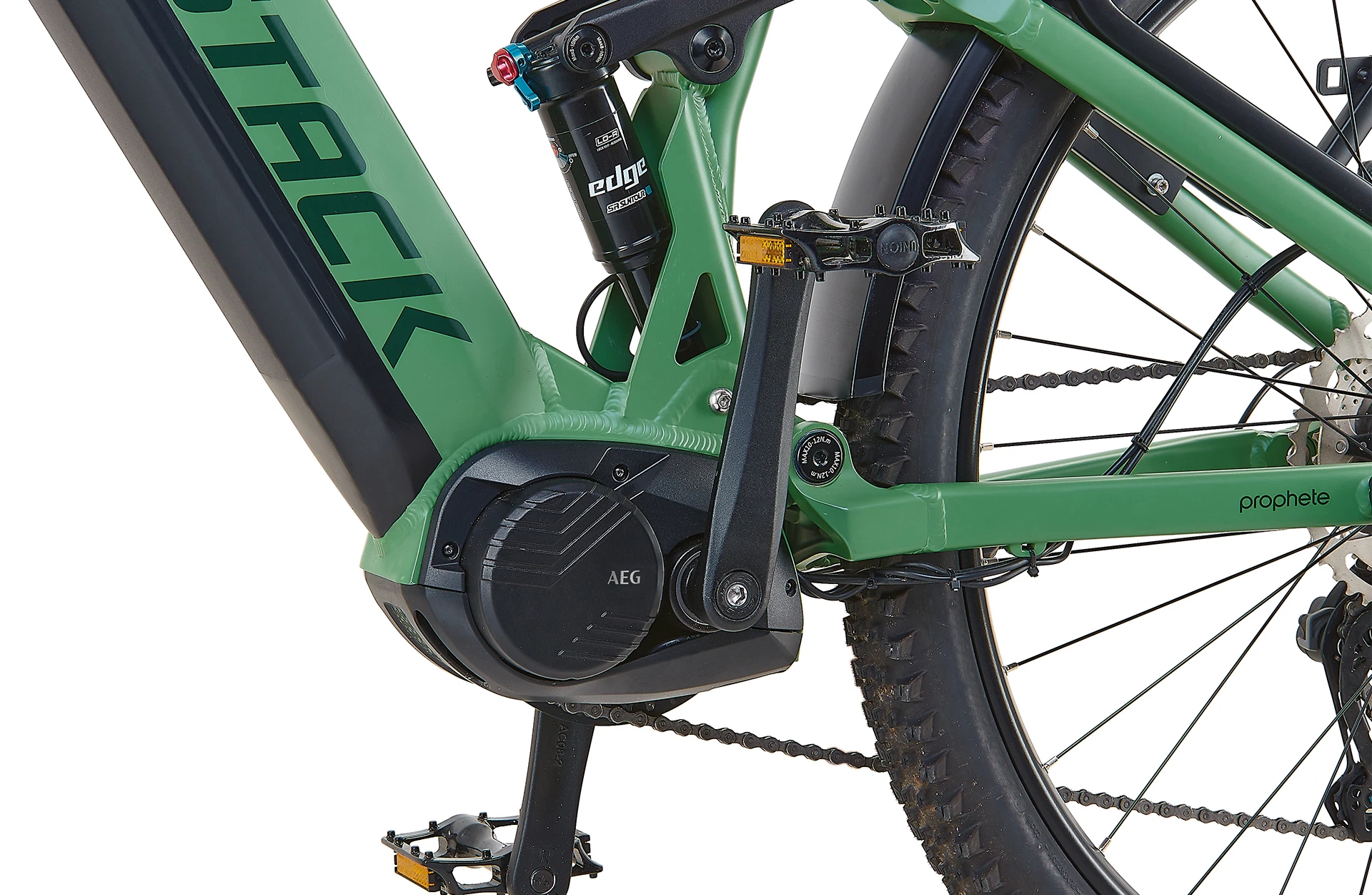 Bildausschnitt AEG Mittelmotor mit Kurbelgarnitur und Pedalen, sowie angeschnittenen Reifen, STACK Logo und Luftdämpfer am Hinterbau vor weißem Hintergrund