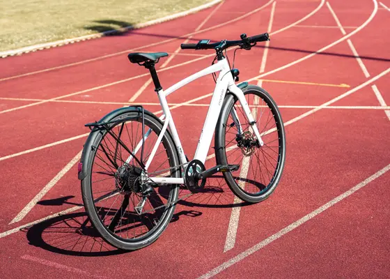 Urban E-Bike auf roter Laufbahn mit sportlichem Hintergrund
