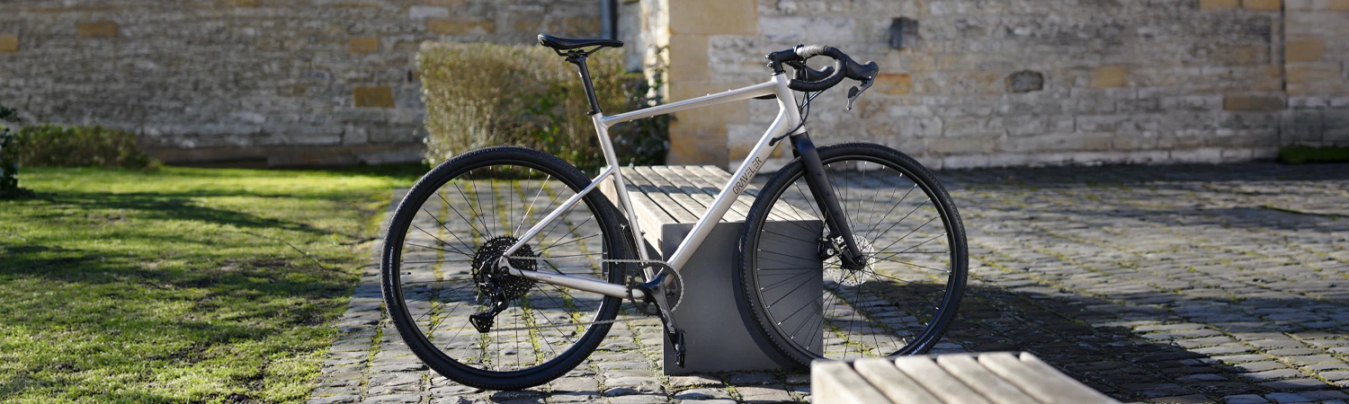 Graveler Gravel Bike - Ansicht seitlich an einer Bank im Freien