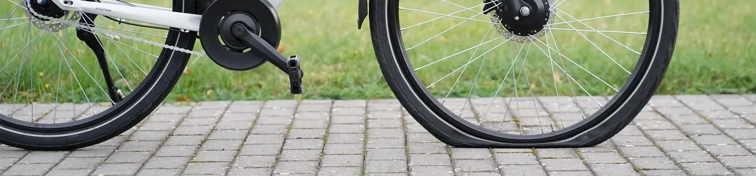 Fahrrad mit plattem Reifen auf gepflastertem Weg – Tipps zum Reifenwechsel bei Panne