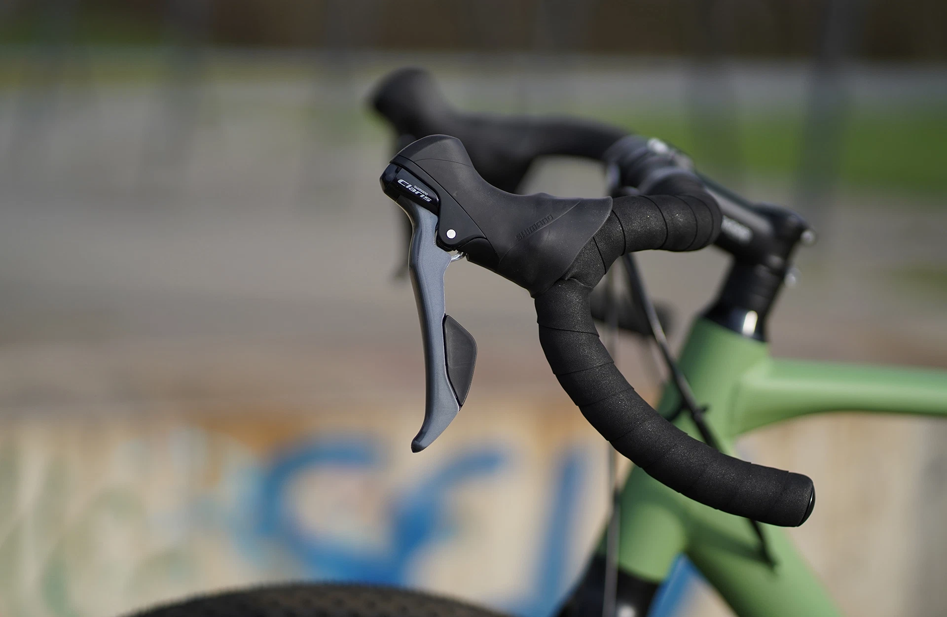 Bildausschnitt Detailansicht Dropbar Rennrad Lenker mit Lenkerband und Bremse vor unscharfem Hintergrund