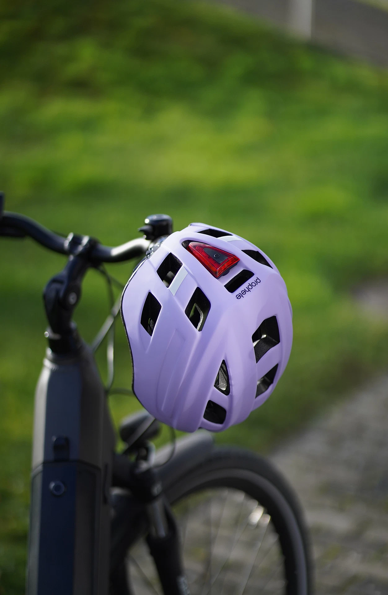 Fahrradhelm lila hängt an Fahrradlenker im Freien - Ansicht von hinten