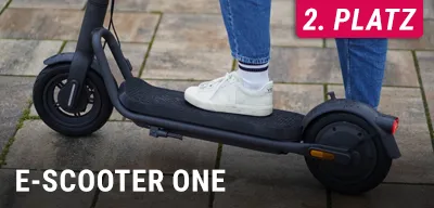 Person steht mit weißen Sneakern auf schwarzem E‑Scooter, unten Text E‑Scooter One, oben rechts 2. Platz