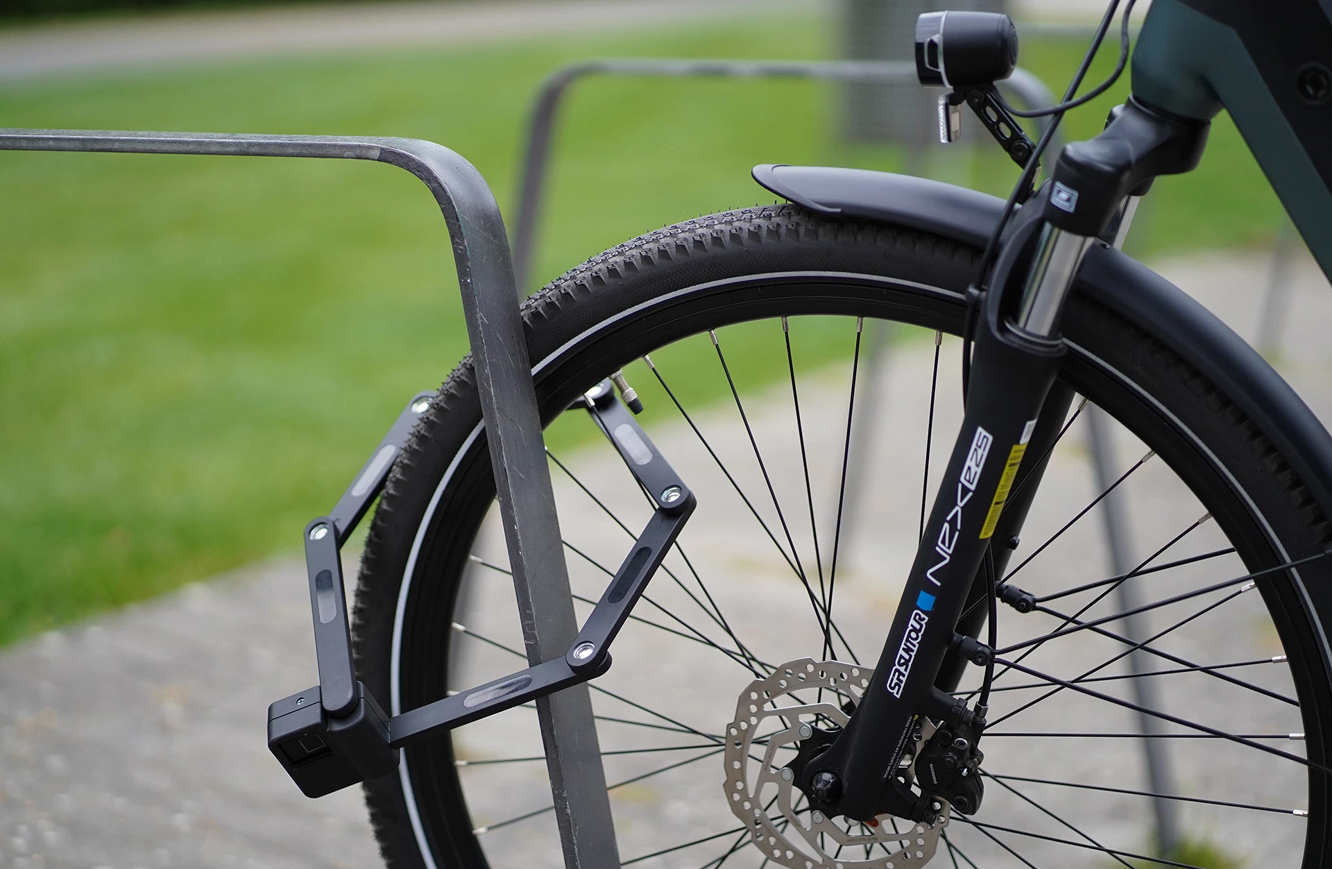 Faltschloss abgeschlossen mit Rad an Fahrradständer