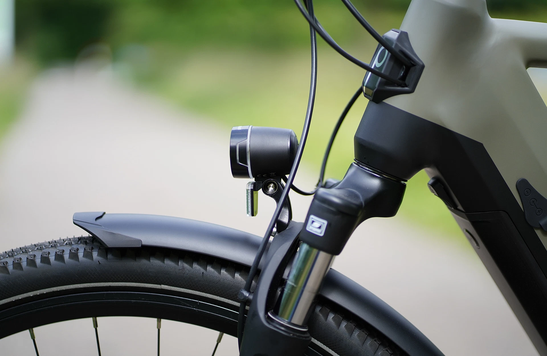 Bildausschnitt Detailaufnahme Scheinwerfer und Federgabel im Anschnitt mit Prophete Logo am Steuerrohr vor unscharfem Hintergrund