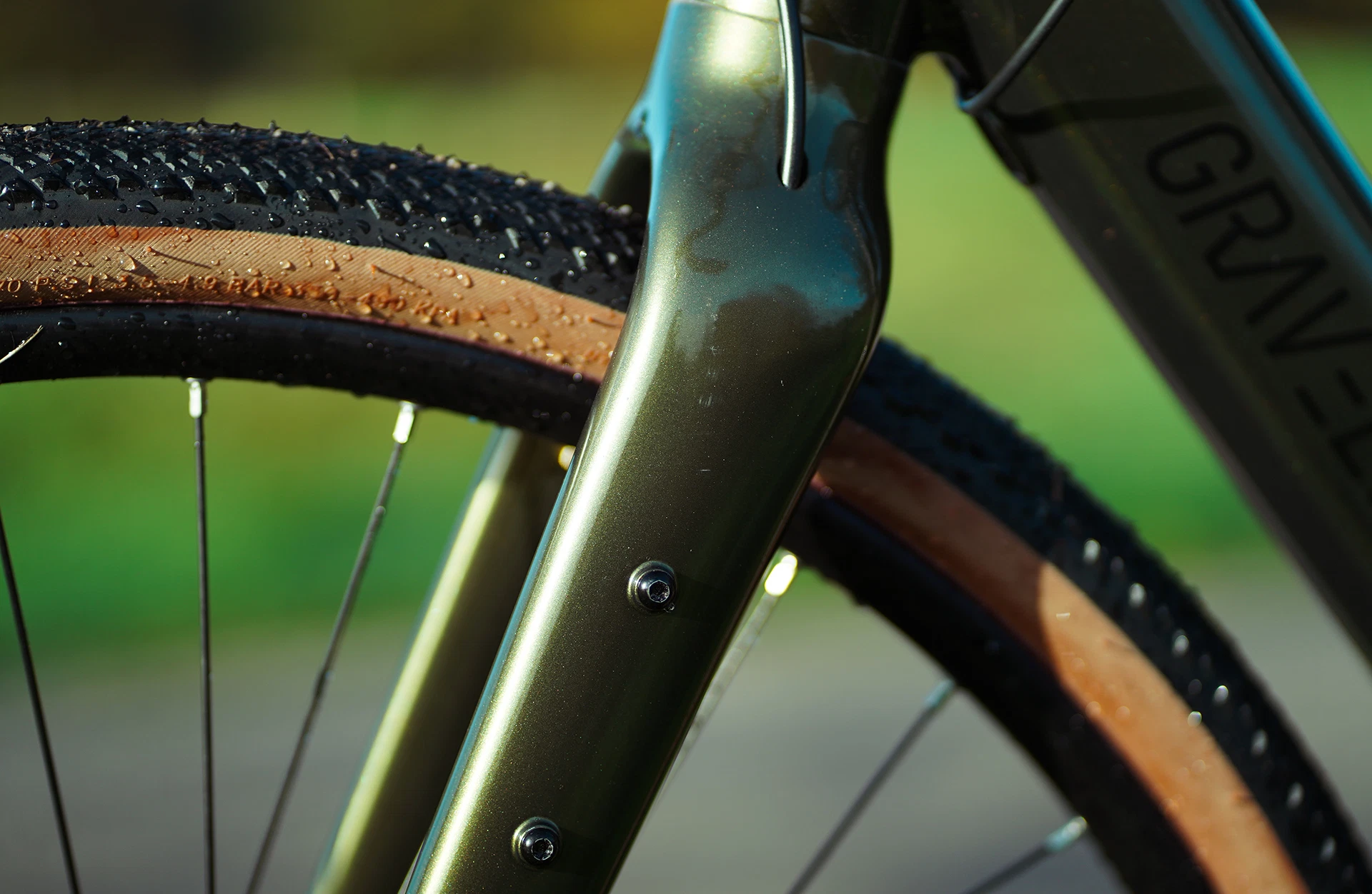 Bildausschnitt Vorderrad im Anschnitt mit starrer Gabel und Graveler Logo auf Unterrohr vor unscharfem Hintergrund
