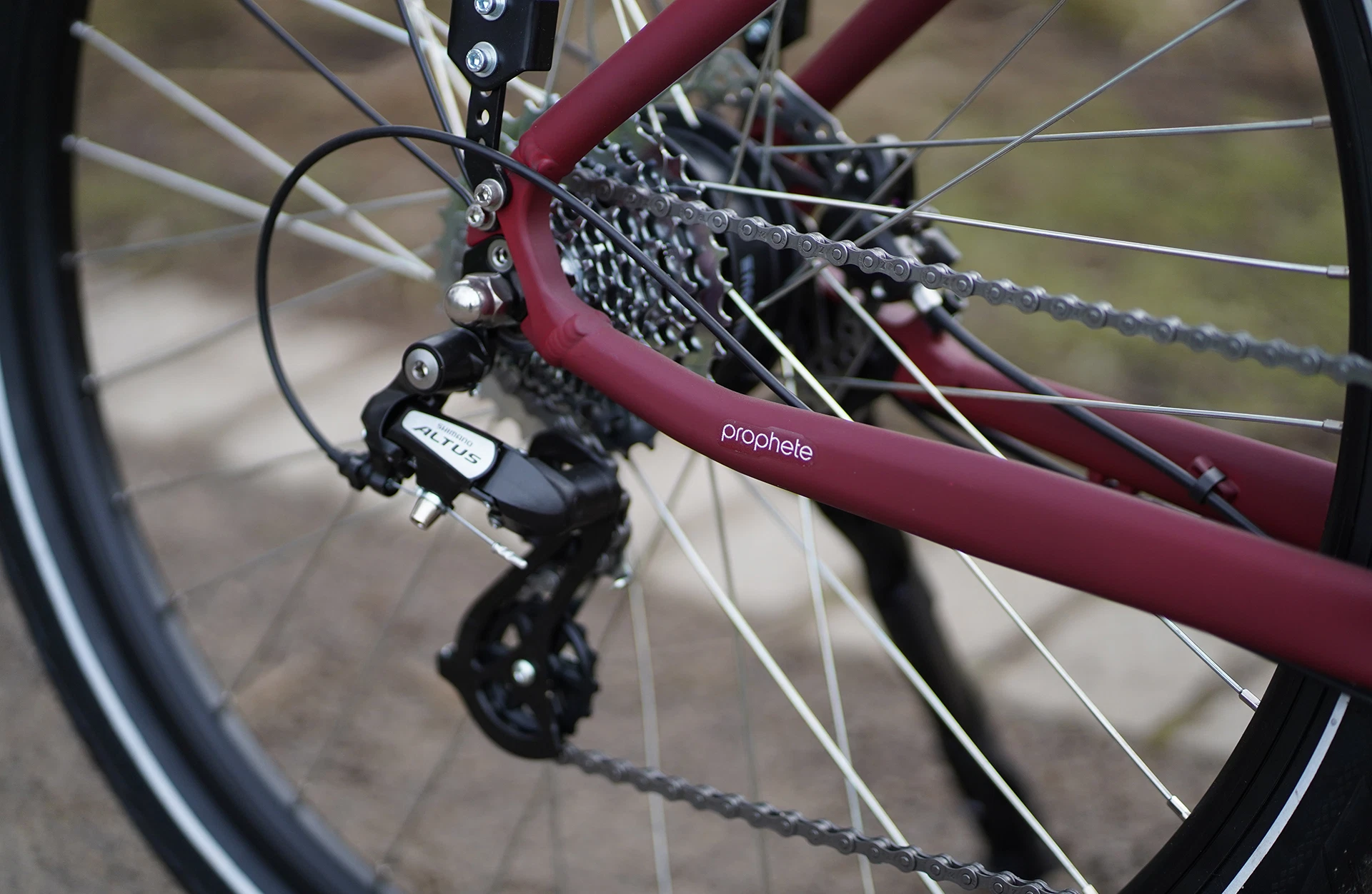 Bildausschnitt Detailansicht Shimano Altus Schaltung mit Teil vom Hinterbau im Anschnitt vor unscharfem Hintergrund