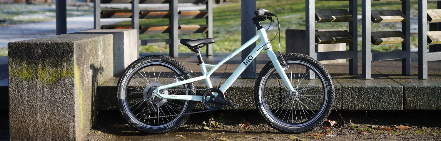 Kinderfahrrad im Außenbereich vor Beton- und Metallkonstruktion abgestellt