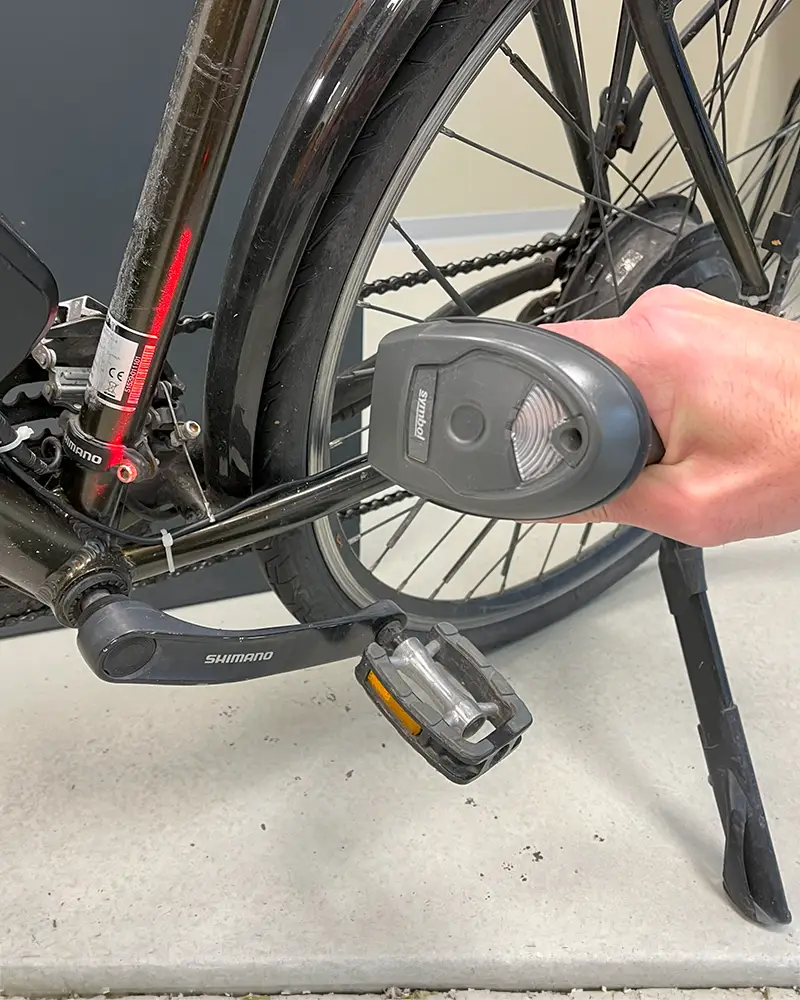 Scanner mit Hand vor E-Bike Hinterbau im Anschnitt