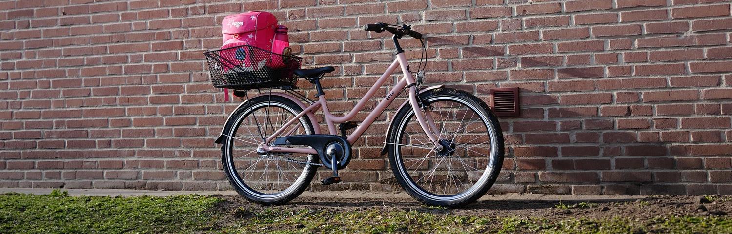 Kinderfahrrad altrosa - an Hauswand lehnend im Freien