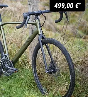 Gravel-Bike steht am Rand eines Feldwegs neben einem Zaun.