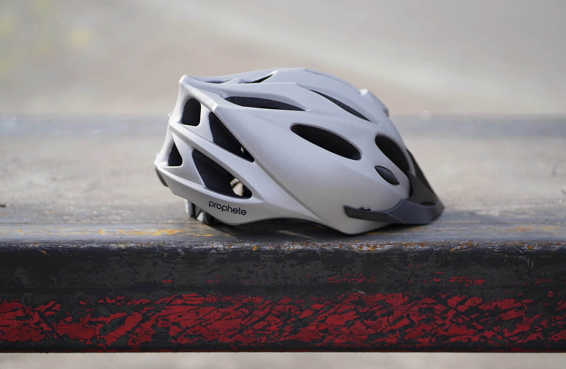 Fahrradhelm silber auf Stein - seitliche Ansicht