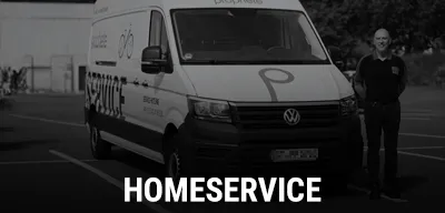 Servicefahrzeug mit Fahrrad‑Branding steht auf einem Parkplatz, daneben eine Person, Text Homeservice