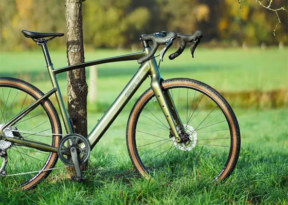 Gravelbike auf einer Wiese mit natürlicher Landschaft im Hintergrund