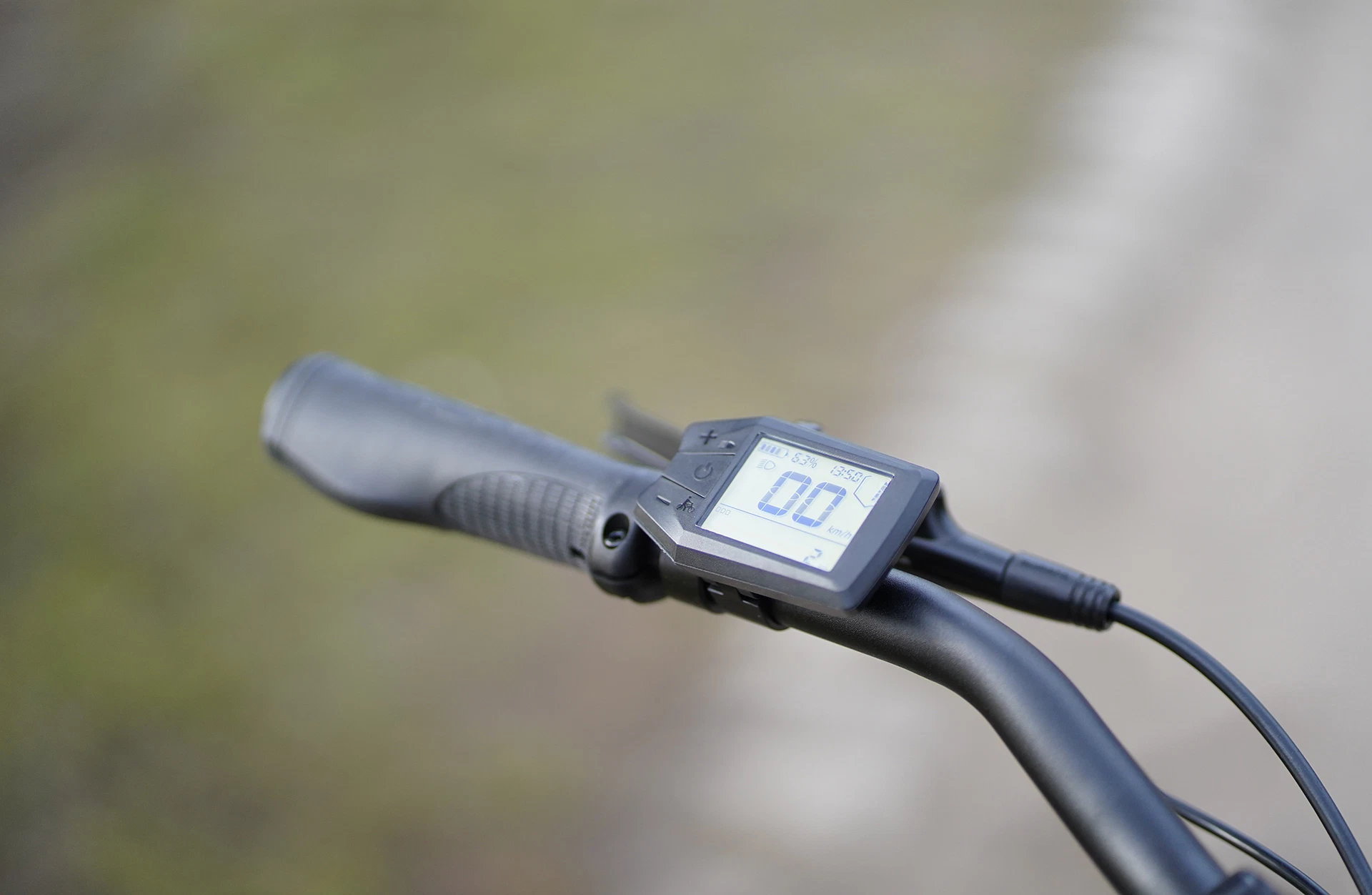 Bildausschnitt Detailansicht mit angeschaltetem LCD Display am Lenker vor unscharfem Hintergrund