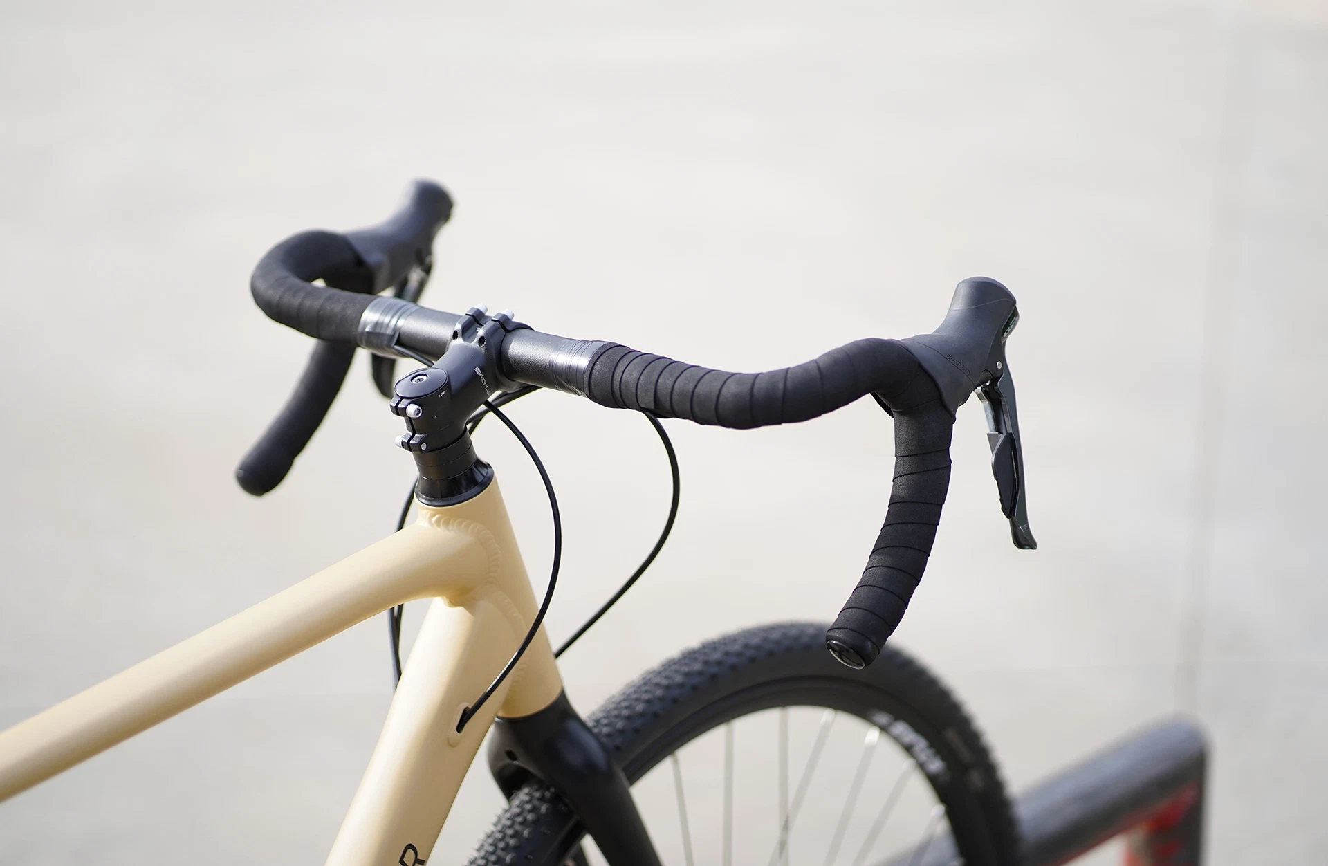 Bildausschnitt Lenker schräg von hinten mit Griffhörnchen, Bremshebeln und Lenkerband vor unscharfem Hintergrund