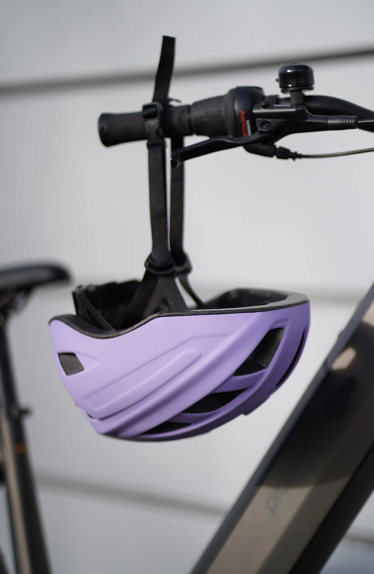 Fahrradhelm lila hängt an Fahrradlenker - Detailansicht
