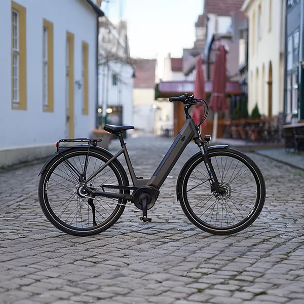 Geniesser 3.3 E‑Bike steht auf einer gepflasterten Altstadtstraße zwischen historischen Häusern