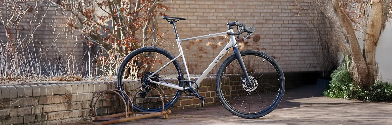 Gravelbike draußen vor einer niedrigen Backsteinmauer abgestellt
