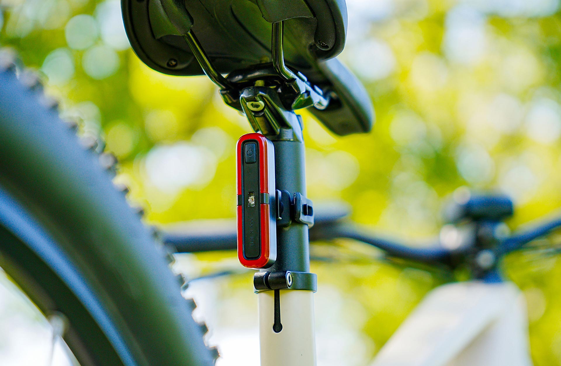 Vollansicht hinten unten Rücklicht mit LED Light Line an Sattelstütze mit E-Bike im Anschnitt vor unscharfem Naturhintergrund